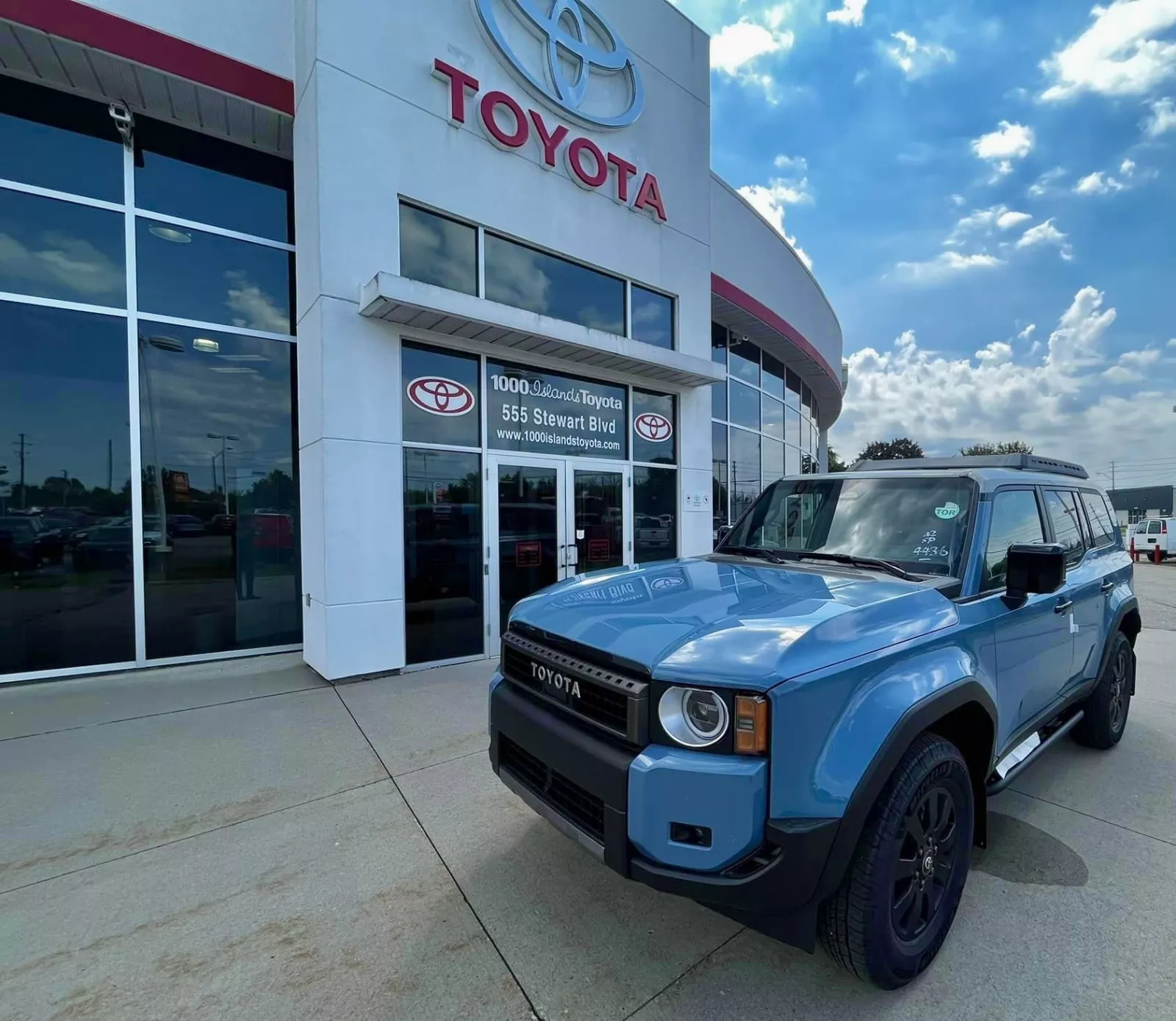 1000 Islands Toyota Dealership with blue Toyota vehicle